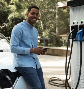 Image d'un homme qui recharge sa voiture éléctrique a la borne